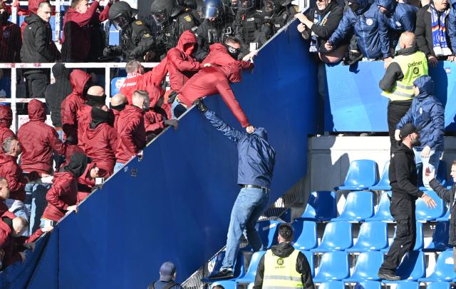 FILED - 18 October 2025, Karlsruhe: Fan groups clash in the stands during the German 2nd Bundesliga soccer match between Karlsruher SC and 1. FC Kaiserslautern at the BBBank Wildpark. Photo: Uli Deck/dpa - IMPORTANT NOTE: In accordance with the regulations of the DFL German Football League and the DFB German Football Association, it is prohibited to utilize or have utilized photographs taken in the stadium and/or of the match in the form of sequential images and/or video-like photo series.