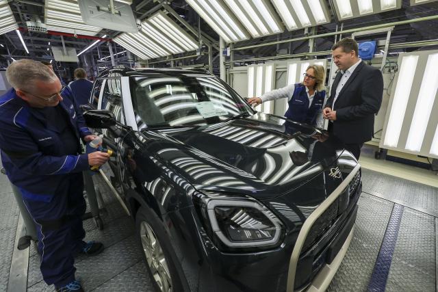 24 October 2025, Saxony, Leipzig: Petra Peterhaensel (C), Head of BMW Group Plant Leipzig, explains the quality control in the light tunnel at BMW Group Plant Leipzig to Sven Schulze (R), Saxony-Anhalt's Minister of Economic Affairs. Around 6800 employees currently produce the 1 Series, the 2 Series Gran Coupe, the 2 Series Active Tourer and the Mini Countryman in Leipzig. Photo: Jan Woitas/dpa