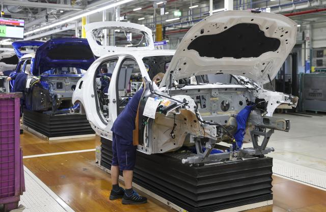 24 October 2025, Saxony, Leipzig: Employees work on a BMW 1 Series at the BMW Group plant in Leipzig. Around 6800 employees currently produce the 1 Series, the 2 Series Gran Coupe, the 2 Series Active Tourer and the Mini Countryman in Leipzig. Photo: Jan Woitas/dpa