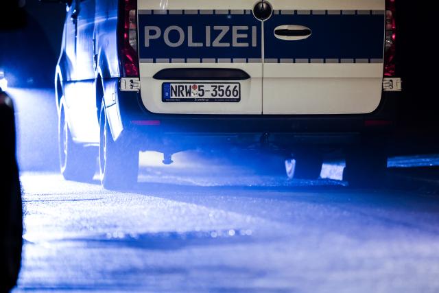 FILED - 07 October 2025, North Rhine-Westphalia, Herdecke: A police vehicle stands at the roadside after the newly elected mayor of Herdecke, Iris Stalzer, was critically wounded with several stab wounds. Prosecutors have obtained a warrant for the arrest of Stalzer's adopted daughter who was suspected of the crime. Photo: Christoph Reichwein/dpa