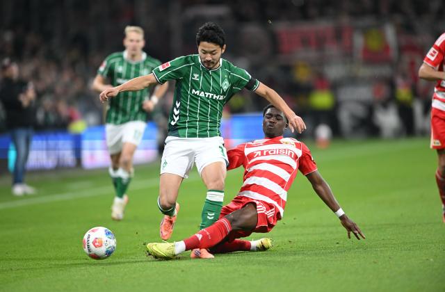 24 October 2025, Bremen: Werder Bremen's Yukinara Sugawara (L) and Union Berlin's Derrick Koehn battle for the ball during the German Bundesliga soccer match between Werder Bremen and 1.FC Union Berlin at Weserstadion. Photo: Carmen Jaspersen/dpa - IMPORTANT NOTICE: DFL and DFB regulations prohibit any use of photographs as image sequences and/or quasi-video.