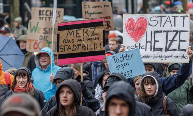 25 October 2025, Hamburg: People hold placards and flags during a rally against Chancellor Merz's statements on the cityscape and migration in Hamburg. Photo: Markus Scholz/dpa