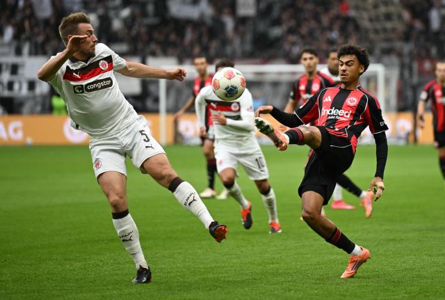 25 October 2025, Hesse, Frankfurt_Main: Eintracht Frankfurt's Nathaniel Brown and St. Pauli's Hauke Wahl battle for the ball during the German Bundesliga soccer match between Eintracht Frankfurt and FC St. Pauli at Deutsche Bank Park. Photo: Arne Dedert/dpa - IMPORTANT NOTICE: DFL and DFB regulations prohibit any use of photographs as image sequences and/or quasi-video.