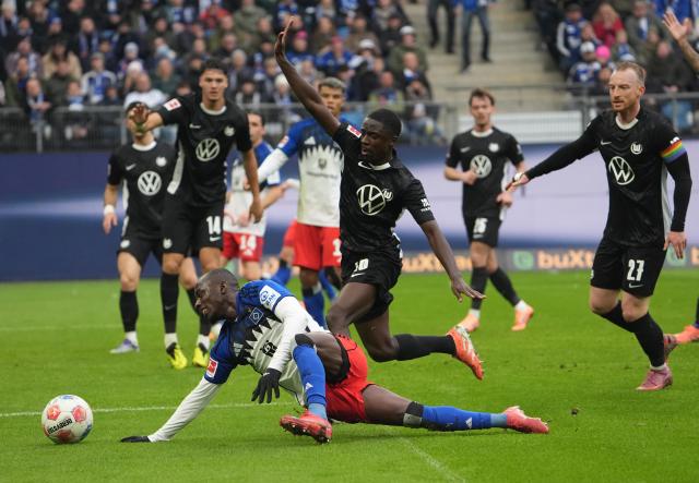 25 October 2025, Hamburg: Hamburger's Jean-Luc Dompe and Wolfsburg's Sael Kumbedi battle for the ball battle for the ball during the German Bundesliga soccer match between Hamburger SV and VfL Wolfsburg at the Volksparkstadion. Photo: Marcus Brandt/dpa - IMPORTANT NOTICE: DFL and DFB regulations prohibit any use of photographs as image sequences and/or quasi-video.