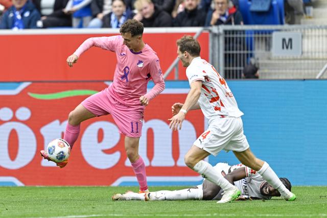 25 October 2025, Sinsheim: Hoffenheim's Fisnik Asllani (L) and Heidenheim's Tim Siersleben battle for the ball during the German Bundesliga soccer match between TSG 1899 Hoffenheim and 1. FC Heidenheim at the PreZero Arena. Photo: Uwe Anspach/dpa - IMPORTANT NOTICE: DFL and DFB regulations prohibit any use of photographs as image sequences and/or quasi-video.