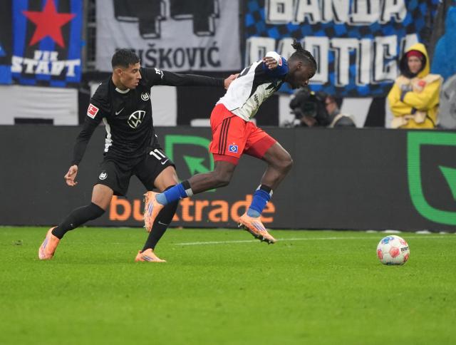 25 October 2025, Hamburg: Wolfsburg's Adam Daghim (L) and Hamburger's Fabio Balde battle for the ball during the German Bundesliga soccer match between Hamburger SV and VfL Wolfsburg at the Volksparkstadion. Photo: Marcus Brandt/dpa - IMPORTANT NOTICE: DFL and DFB regulations prohibit any use of photographs as image sequences and/or quasi-video.