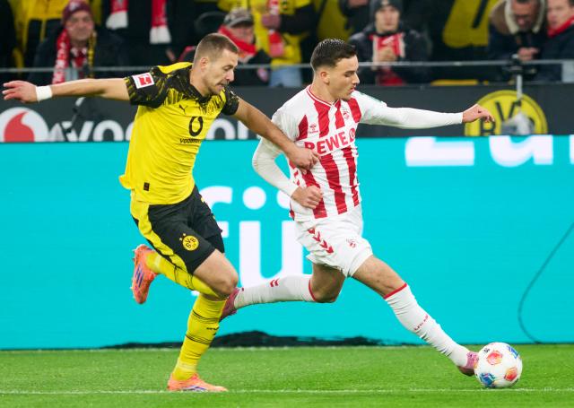 25 October 2025, North Rhine-Westphalia, Dortmund: Borussia Dortmund's Waldemar Anton (L) and Cologne's Said El Mala in action during the German Bundesliga soccer match between Borussia Dortmund and 1. FC Cologne at the Signal Iduna Park. Photo: Bernd Thissen/dpa - IMPORTANT NOTICE: DFL and DFB regulations prohibit any use of photographs as image sequences and/or quasi-video.