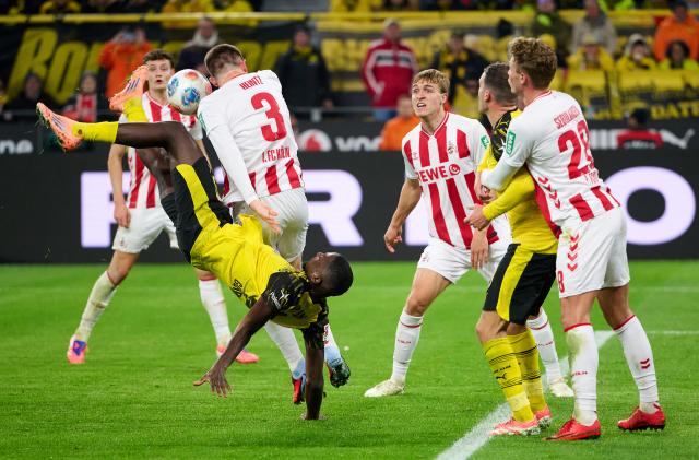 25 October 2025, North Rhine-Westphalia, Dortmund: Borussia Dortmund's Serhou Guirassy and Cologne's Dominique Heintz in action during the German Bundesliga soccer match between Borussia Dortmund and 1. FC Cologne at the Signal Iduna Park. Photo: Bernd Thissen/dpa - IMPORTANT NOTICE: DFL and DFB regulations prohibit any use of photographs as image sequences and/or quasi-video.
