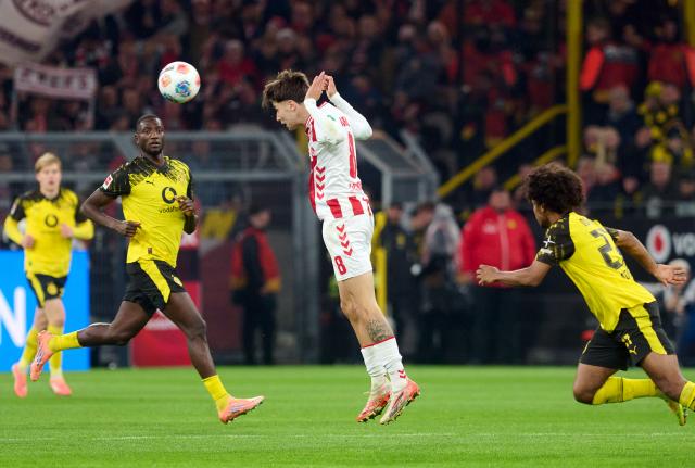 25 October 2025, North Rhine-Westphalia, Dortmund: Cologne's Denis Huseinbasic in action in front of Borussia Dortmund's Serhou Guirassy during the German Bundesliga soccer match between Borussia Dortmund and 1. FC Cologne at the Signal Iduna Park. Photo: Bernd Thissen/dpa - IMPORTANT NOTICE: DFL and DFB regulations prohibit any use of photographs as image sequences and/or quasi-video.