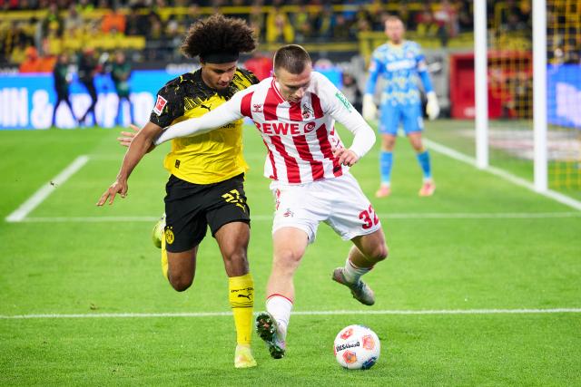 25 October 2025, North Rhine-Westphalia, Dortmund: Borussia Dortmund's Karim Adeyemi and Cologne's Kristoffer Lund in actionduring the German Bundesliga soccer match between Borussia Dortmund and 1. FC Cologne at the Signal Iduna Park. Photo: Bernd Thissen/dpa - IMPORTANT NOTICE: DFL and DFB regulations prohibit any use of photographs as image sequences and/or quasi-video.