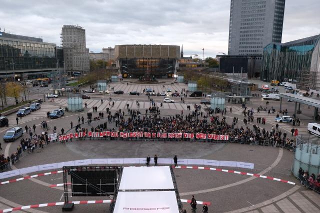 25 October 2025, Saxony, Leipzig: Activists hold up the slogan "Tell me who you're partying with and I'll tell you who you are" as they gather on Augustusplatz to protest against the participation of Rammstein singer Lindemann at the Leipzig Opera Ball. Photo: Sebastian Willnow/dpa
