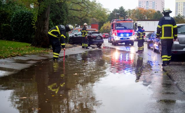 26 October 2025, Hamburg: Firefighters stand by a flooded street in the Lohbruegge district after heavy rain. Photo: Daniel Bockwoldt/dpa