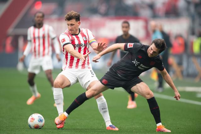 26 October 2025, North Rhine-Westphalia, Leverkusen: SC Freiburg's Maximilian Eggestein (L) and Bayer Leverkusen's Jonas Hofmann battle for the ball during the German Bundesliga soccer match between Bayer Leverkusen and SC Freiburg at BayArena. Photo: Marius Becker/dpa - WICHTIGER HINWEIS: Gemäß den Vorgaben der DFL Deutsche Fußball Liga bzw. des DFB Deutscher Fußball-Bund ist es untersagt, in dem Stadion und/oder vom Spiel angefertigte Fotoaufnahmen in Form von Sequenzbildern und/oder videoähnlichen Fotostrecken zu verwerten bzw. verwerten zu lassen.