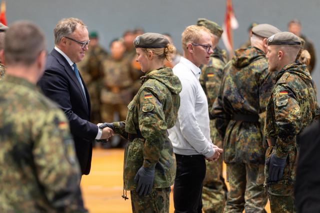 26 October 2025, Thuringia, Oberhof: Minister President of Thuringia Mario Voigt (L) congratulates soldiers of the Bundeswehr's Homeland Security Regiment 5 at a public regimental roll call in the sports hall after their pledge. Photo: Michael Reichel/dpa