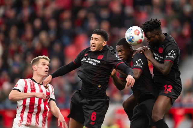 26 October 2025, North Rhine-Westphalia, Leverkusen: Leverkusen's Ezequiel Fernandez (2nd L), Christian Kofane and Edmond Tapsoba (R) try to get the ball before Freiburg's Matthias Ginter (R) during the German Bundesliga soccer match between Bayer Leverkusen and SC Freiburg at BayArena. Photo: Marius Becker/dpa - WICHTIGER HINWEIS: Gemäß den Vorgaben der DFL Deutsche Fußball Liga bzw. des DFB Deutscher Fußball-Bund ist es untersagt, in dem Stadion und/oder vom Spiel angefertigte Fotoaufnahmen in Form von Sequenzbildern und/oder videoähnlichen Fotostrecken zu verwerten bzw. verwerten zu lassen.
