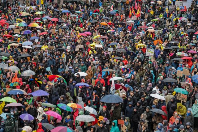 26 October 2025, Bremen: People with umbrellas and flags take part in a rally at the Domshof against statements by German Chancellor Friedrich Merz on the cityscape and migration. Photo: Focke Strangmann/dpa