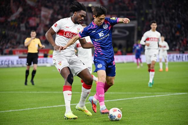26 October 2025, Baden-Wuerttemberg, Stuttgart: Stuttgart's Dan-Axel Zagadou (L) and FSV Mainz's Kaishu Sano battle for the ball during the German Bundesliga soccer match between VfB Stuttgart and FSV Mainz 05 at the MHPArena. Photo: Marijan Murat/dpa - WICHTIGER HINWEIS: Gemäß den Vorgaben der DFL Deutsche Fußball Liga bzw. des DFB Deutscher Fußball-Bund ist es untersagt, in dem Stadion und/oder vom Spiel angefertigte Fotoaufnahmen in Form von Sequenzbildern und/oder videoähnlichen Fotostrecken zu verwerten bzw. verwerten zu lassen.