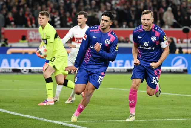 26 October 2025, Baden-Wuerttemberg, Stuttgart: FSV Mainz's Nadiem Amiri (C) celebrates scoring his side's first goal with teammate Silvan Widmer during the German Bundesliga soccer match between VfB Stuttgart and FSV Mainz 05 at the MHPArena. Photo: Marijan Murat/dpa - WICHTIGER HINWEIS: Gemäß den Vorgaben der DFL Deutsche Fußball Liga bzw. des DFB Deutscher Fußball-Bund ist es untersagt, in dem Stadion und/oder vom Spiel angefertigte Fotoaufnahmen in Form von Sequenzbildern und/oder videoähnlichen Fotostrecken zu verwerten bzw. verwerten zu lassen.