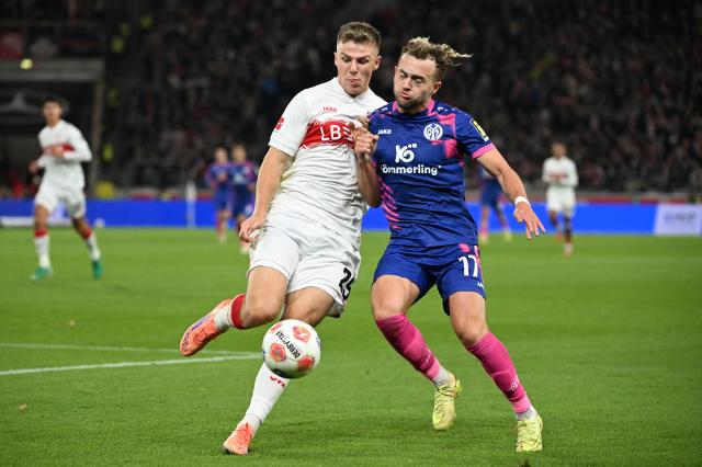 26 October 2025, Baden-Wuerttemberg, Stuttgart: Stuttgart's Finn Jeltsch (L) and FSV Mainz's Benedict Hollerbach battle for the ball during the German Bundesliga soccer match between VfB Stuttgart and FSV Mainz 05 at the MHPArena. Photo: Marijan Murat/dpa - WICHTIGER HINWEIS: Gemäß den Vorgaben der DFL Deutsche Fußball Liga bzw. des DFB Deutscher Fußball-Bund ist es untersagt, in dem Stadion und/oder vom Spiel angefertigte Fotoaufnahmen in Form von Sequenzbildern und/oder videoähnlichen Fotostrecken zu verwerten bzw. verwerten zu lassen.