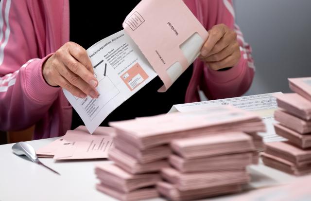 26 October 2025, Bavaria, Munich: Election workers prepare to count the postal ballot documents for the referendum on Munich's bid to host the Olympic and Paralympic Games at the Riem school campus. Photo: Sven Hoppe/dpa