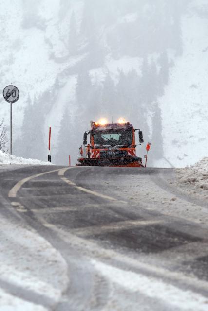27 October 2025, Bavaria, Obermaiselstein: A winter road clearance vehicle drives on the Riedberg Pass in the snow. Photo: Karl-Josef Hildenbrand/dpa