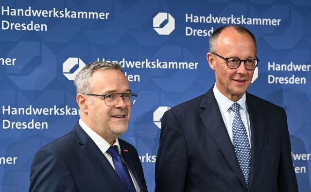 28 October 2025, Saxony, Dresden: Joerg Dittrich (L), President of the Dresden Chamber of Skilled Crafts and the German Confederation of Skilled Crafts (ZDH), receives Germany's Chancellor Friedrich Merz at the training center of the Dresden Chamber of Skilled Crafts. Photo: Hendrik Schmidt/dpa