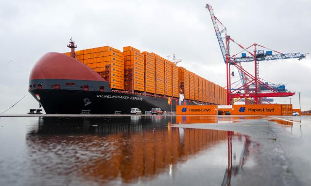 28 October 2025, Lower Saxony, Wilhelmshaven: A view of the container ship "Wilhelmshaven Express" moored at JadeWeserPort. Hapag-Lloyd is christening the vessel, one of the world's largest container ships with space for nearly 24,000 containers, and the twelfth and final ship in its Hamburg class. Photo: Sina Schuldt/dpa
