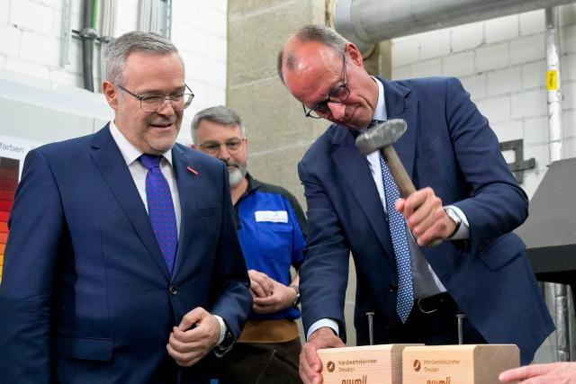 28 October 2025, Saxony, Dresden: German Chancellor Friedrich Merz (R) visits the training center of the Chamber of Skilled Crafts. Photo: Matthias Rietschel/Reuters/Pool/dpa