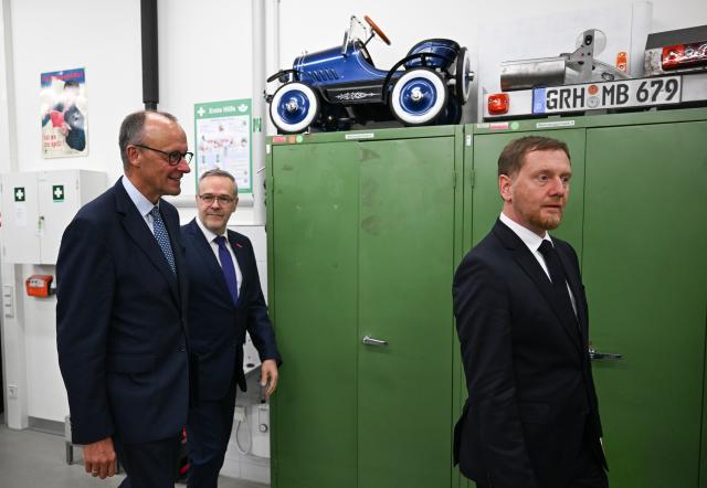 28 October 2025, Saxony, Dresden: (L-R) German Chancellor Friedrich Merz, President of the Dresden Chamber of Skilled Crafts and the German Confederation of Skilled Crafts (ZDH) Joerg Dittrich and Minister President of Saxony Michael Kretschmer visit the training center of the Dresden Chamber of Skilled Crafts. Photo: Hendrik Schmidt/dpa
