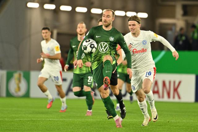 28 October 2025, Lower Saxony, Wolfsburg: VfL Wolfsburg's Christian Eriksen and Holstein Kiel's Jonas Therkelsen battle for the ball during the German DFB Cup 2nd round soccer match between VfL Wolfsburg and Holstein Kiel at Volkswagen Arena. Photo: Swen Pförtner/dpa - WICHTIGER HINWEIS: Gemäß den Vorgaben der DFL Deutsche Fußball Liga bzw. des DFB Deutscher Fußball-Bund ist es untersagt, in dem Stadion und/oder vom Spiel angefertigte Fotoaufnahmen in Form von Sequenzbildern und/oder videoähnlichen Fotostrecken zu verwerten bzw. verwerten zu lassen.