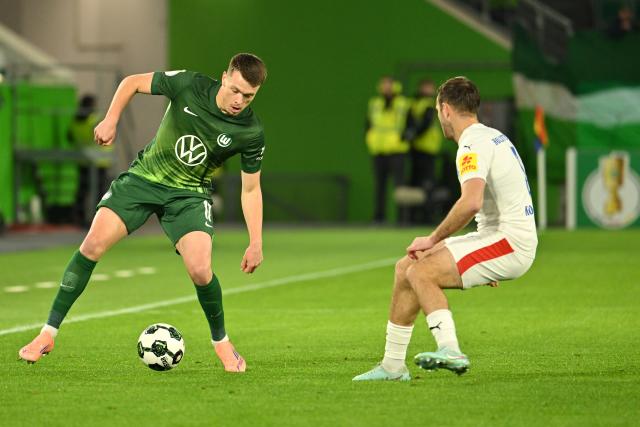 28 October 2025, Lower Saxony, Wolfsburg: VfL Wolfsburg's Dzenan Pejcinovic (L) and Holstein Kiel's Marco Komenda battle for the ball during the German DFB Cup 2nd round soccer match between VfL Wolfsburg and Holstein Kiel at Volkswagen Arena. Photo: Swen Pförtner/dpa - WICHTIGER HINWEIS: Gemäß den Vorgaben der DFL Deutsche Fußball Liga bzw. des DFB Deutscher Fußball-Bund ist es untersagt, in dem Stadion und/oder vom Spiel angefertigte Fotoaufnahmen in Form von Sequenzbildern und/oder videoähnlichen Fotostrecken zu verwerten bzw. verwerten zu lassen.