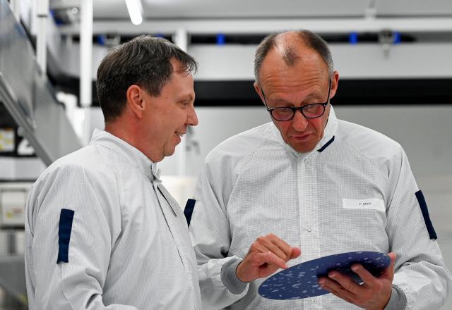 28 October 2025, Saxony, Dresden: German Chancellor Friedrich Merz (R) visits a test laboratory in GlobalFoundries' clean room. Photo: Matthias Rietschel/Reuters/Pool/dpa