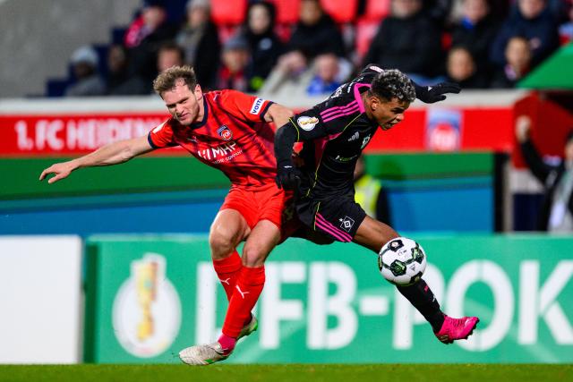 29 October 2025, Baden-Wuerttemberg, Heidenheim: Heidenheim's Tim Siersleben (L) and Hamburger's Ransford Koenigsdoerffer battle for the ball during the German DFB Cup 2nd round soccer match between 1. FC Heidenheim and Hamburger SV at Voith-Arena. Photo: Tom Weller/dpa - WICHTIGER HINWEIS: Gemäß den Vorgaben der DFL Deutsche Fußball Liga bzw. des DFB Deutscher Fußball-Bund ist es untersagt, in dem Stadion und/oder vom Spiel angefertigte Fotoaufnahmen in Form von Sequenzbildern und/oder videoähnlichen Fotostrecken zu verwerten bzw. verwerten zu lassen.