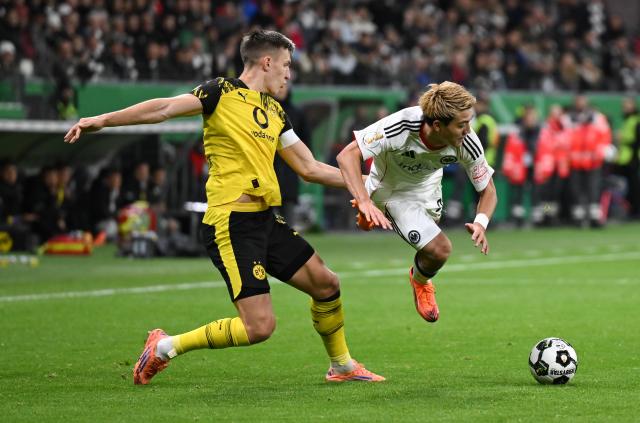 28 October 2025, Hesse, Frankfurt/Main: Eintracht Frankfurt's Ritsu Doan (R) and Borussia Dortmund's Nico Schlotterbeck battle for the ball during the German DFB Cup 2nd round soccer match between Eintracht Frankfurt and Borussia Dortmund at Deutsche Bank Park. Photo: Arne Dedert/dpa - WICHTIGER HINWEIS: Gemäß den Vorgaben der DFL Deutsche Fußball Liga bzw. des DFB Deutscher Fußball-Bund ist es untersagt, in dem Stadion und/oder vom Spiel angefertigte Fotoaufnahmen in Form von Sequenzbildern und/oder videoähnlichen Fotostrecken zu verwerten bzw. verwerten zu lassen.