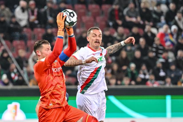 28 October 2025, Bavaria, Augsburg: VfL Bochum's goalkeeper Timo Horn (L) battles for the ball against FC Augsburg's Phillip Tietz during the German DFB Cup 2nd round soccer match between FC Augsburg and VfL Bochum at WWK-Arena. Photo: Harry Langer/dpa - WICHTIGER HINWEIS: Gemäß den Vorgaben der DFL Deutsche Fußball Liga bzw. des DFB Deutscher Fußball-Bund ist es untersagt, in dem Stadion und/oder vom Spiel angefertigte Fotoaufnahmen in Form von Sequenzbildern und/oder videoähnlichen Fotostrecken zu verwerten bzw. verwerten zu lassen.