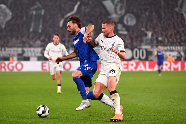 28 October 2025, North Rhine-Westphalia, Moenchengladbach: Borussia Moenchengladbach's Nico Elvedi (R) and Karlsruher's  Fabian Schleusener battle for the ball during the German DFB Cup 2nd round soccer match between Borussia Moenchengladbach and Karlsruher SC at Borussia-Park. Photo: Federico Gambarini/dpa - WICHTIGER HINWEIS: Gemäß den Vorgaben der DFL Deutsche Fußball Liga bzw. des DFB Deutscher Fußball-Bund ist es untersagt, in dem Stadion und/oder vom Spiel angefertigte Fotoaufnahmen in Form von Sequenzbildern und/oder videoähnlichen Fotostrecken zu verwerten bzw. verwerten zu lassen.