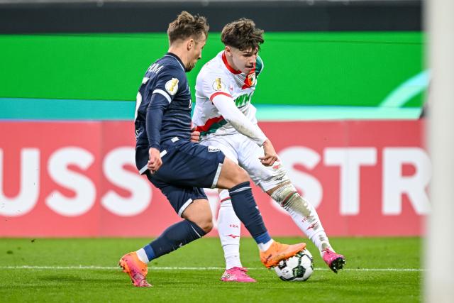 28 October 2025, Bavaria, Augsburg: Bochum's Felix Passlack (L) and Augsburg's Mert Komur battle for the ball during the German DFB Cup 2nd round soccer match between FC Augsburg and VfL Bochum at WWK-Arena. Photo: Harry Langer/dpa - WICHTIGER HINWEIS: Gemäß den Vorgaben der DFL Deutsche Fußball Liga bzw. des DFB Deutscher Fußball-Bund ist es untersagt, in dem Stadion und/oder vom Spiel angefertigte Fotoaufnahmen in Form von Sequenzbildern und/oder videoähnlichen Fotostrecken zu verwerten bzw. verwerten zu lassen.