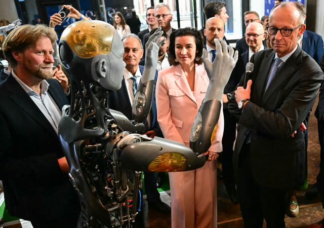 29 October 2025, Berlin: Dorothee Baer (2nd R), German Minister for Research, Technology and Aerospace, and Chancellor Friedrich Merz (R) inspect the humanoid robot "Ameca", designed for the care sector, at the presentation of the so-called "Hightech Agenda Germany - Debate, Conference, Networking" on the EUREF-Campus. Photo: Tobias Schwarz/POOL AFP/dpa