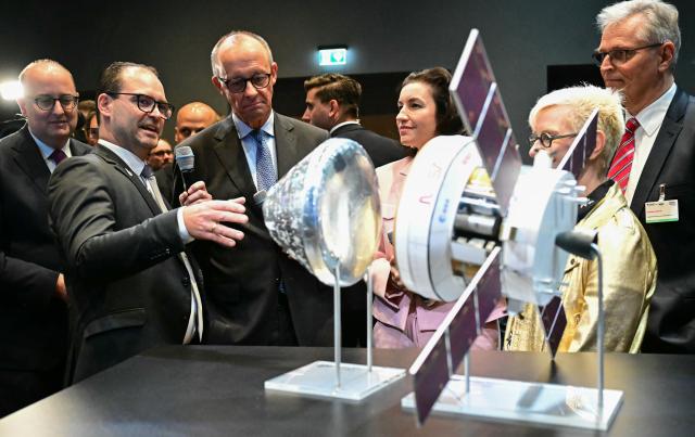 29 October 2025, Berlin: German Chancellor Friedrich Merz (3rd L) and Dorothee Baer (C), Minister for Research, Technology and Aerospace, look at a Nasa and ESA satellite at the presentation of the so-called "Hightech Agenda Germany - Debate, Conference, Networking" on the EUREF-Campus. Photo: Tobias Schwarz/POOL AFP/dpa