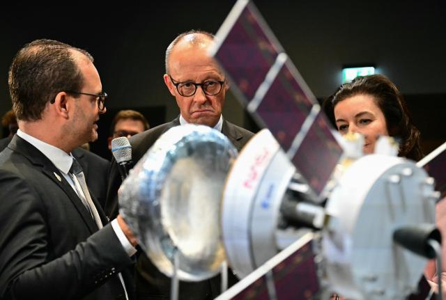 29 October 2025, Berlin: German Chancellor Friedrich Merz (3rd L) and Dorothee Baer (C), Minister for Research, Technology and Aerospace, look at a Nasa and ESA satellite at the presentation of the so-called "Hightech Agenda Germany - Debate, Conference, Networking" on the EUREF-Campus. Photo: Tobias Schwarz/POOL AFP/dpa
