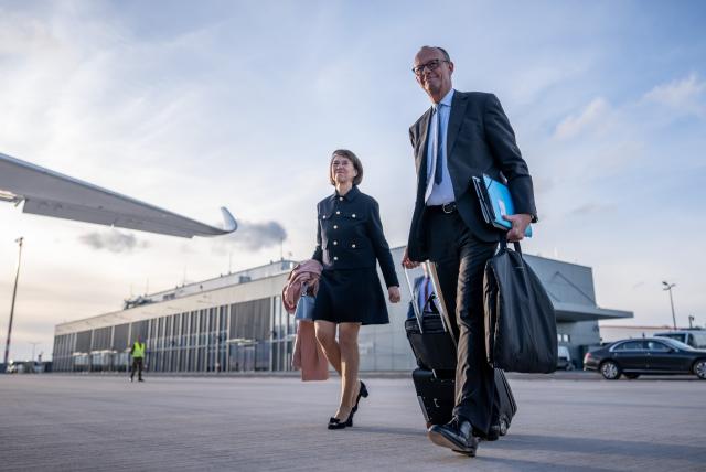 29 October 2025, Brandenburg, Schoenefeld: German Chancellor Friedrich Merz (R) walks alongside his wife Charlotte to an air force plane to fly to Turkey. Photo: Michael Kappeler/dpa