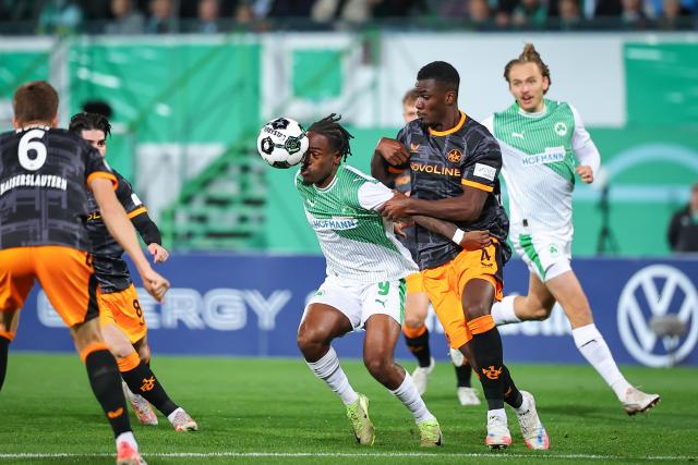 29 October 2025, Bavaria, Fuerth: SpVgg Greuther Fuerth's Noel Futkeu (C) and 1. FC Kaiserslautern's Maxwell Gyamfi (R) battle for the ball during the German DFB Cup 2nd round soccer match between SpVgg Greuther Fuerth and 1. FC Kaiserslautern at Sportpark Ronhof Thomas Sommer. Photo: Daniel Karmann/dpa - WICHTIGER HINWEIS: Gemäß den Vorgaben der DFL Deutsche Fußball Liga bzw. des DFB Deutscher Fußball-Bund ist es untersagt, in dem Stadion und/oder vom Spiel angefertigte Fotoaufnahmen in Form von Sequenzbildern und/oder videoähnlichen Fotostrecken zu verwerten bzw. verwerten zu lassen.