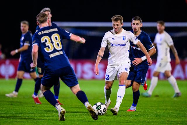 29 October 2025, Bavaria, Illertissen: Magdeburg's Connor Krempicki (C) and Illertissen's Maximilian Neuberger (L) battle for the ball during the German DFB Cup 2nd round soccer match between FV Illertissen and 1. FC Magdeburg at Voehlin Stadium. Photo: Tom Weller/dpa - WICHTIGER HINWEIS: Gemäß den Vorgaben der DFL Deutsche Fußball Liga bzw. des DFB Deutscher Fußball-Bund ist es untersagt, in dem Stadion und/oder vom Spiel angefertigte Fotoaufnahmen in Form von Sequenzbildern und/oder videoähnlichen Fotostrecken zu verwerten bzw. verwerten zu lassen.