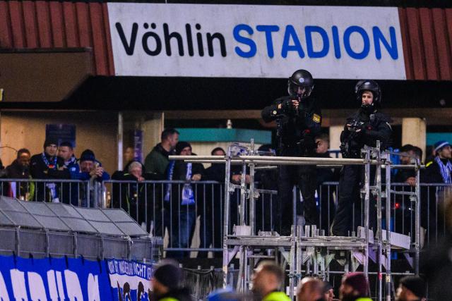 29 October 2025, Bavaria, Illertissen: Police officers watch Magdeburg fans during the German DFB Cup 2nd round soccer match between FV Illertissen and 1. FC Magdeburg at Voehlin Stadium. Photo: Tom Weller/dpa - WICHTIGER HINWEIS: Gemäß den Vorgaben der DFL Deutsche Fußball Liga bzw. des DFB Deutscher Fußball-Bund ist es untersagt, in dem Stadion und/oder vom Spiel angefertigte Fotoaufnahmen in Form von Sequenzbildern und/oder videoähnlichen Fotostrecken zu verwerten bzw. verwerten zu lassen.