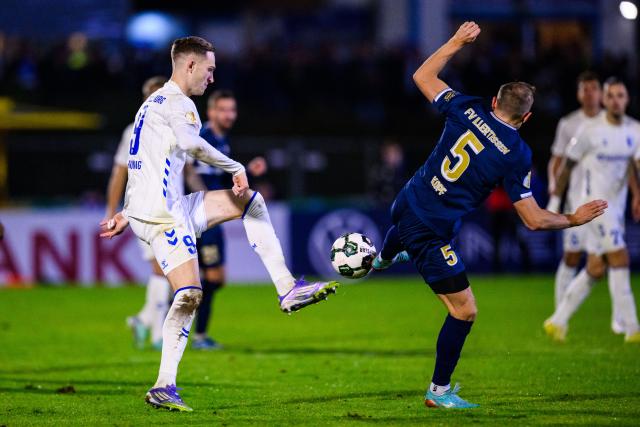 29 October 2025, Bavaria, Illertissen: Magdeburg's Maximilian Breunig (L) and Illertissen's Alexander Kopf battle for the ball during the German DFB Cup 2nd round soccer match between FV Illertissen and 1. FC Magdeburg at Voehlin Stadium. Photo: Tom Weller/dpa - WICHTIGER HINWEIS: Gemäß den Vorgaben der DFL Deutsche Fußball Liga bzw. des DFB Deutscher Fußball-Bund ist es untersagt, in dem Stadion und/oder vom Spiel angefertigte Fotoaufnahmen in Form von Sequenzbildern und/oder videoähnlichen Fotostrecken zu verwerten bzw. verwerten zu lassen.