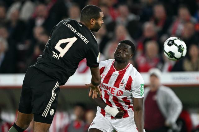 29 October 2025, North Rhine-Westphalia, Cologne: Cologne's Ragnar Ache (R) and Bayern Munich's Jonathan Tah battle for the ball during the German DFB Cup 2nd round soccer match between 1. FC Cologne and Bayern Munich at RheinEnergieStadion. Photo: Federico Gambarini/dpa - WICHTIGER HINWEIS: Gemäß den Vorgaben der DFL Deutsche Fußball Liga bzw. des DFB Deutscher Fußball-Bund ist es untersagt, in dem Stadion und/oder vom Spiel angefertigte Fotoaufnahmen in Form von Sequenzbildern und/oder videoähnlichen Fotostrecken zu verwerten bzw. verwerten zu lassen.