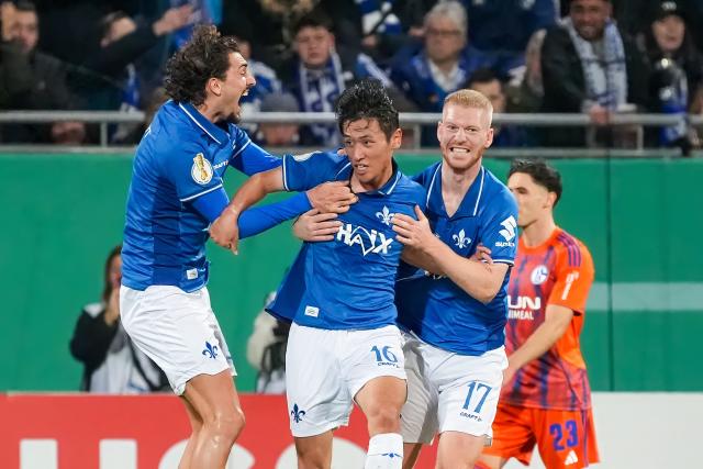 29 October 2025, Hesse, Darmstadt: Darmstadt's Hiroki Akiyama (C) celebrates scoring his side's first goal with teammates Frasier Hornby (L) and Kai Klefisch during the German DFB Cup 2nd round soccer match between Darmstadt 98 and FC Schalke 04 at Merck-Stadion am Boellenfalltor. Photo: Marc Schüler/dpa - WICHTIGER HINWEIS: Gemäß den Vorgaben der DFL Deutsche Fußball Liga bzw. des DFB Deutscher Fußball-Bund ist es untersagt, in dem Stadion und/oder vom Spiel angefertigte Fotoaufnahmen in Form von Sequenzbildern und/oder videoähnlichen Fotostrecken zu verwerten bzw. verwerten zu lassen.
