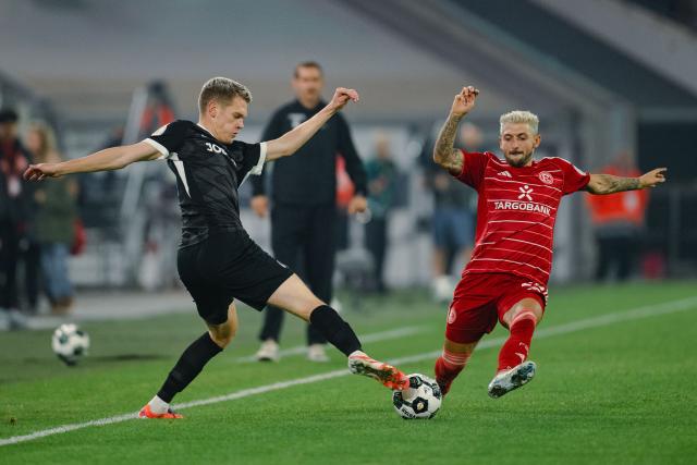 29 October 2025, North Rhine-Westphalia, Duesseldorf: Fortuna Duesseldorf's Matthias Zimmermann (R) and Freiburg's Matthias Ginter battle for the ball during the German DFB Cup 2nd round soccer match between Fortuna Düsseldorf and SC Freiburg at Merkur Spiel-Arena. Photo: Marius Becker/dpa - WICHTIGER HINWEIS: Gemäß den Vorgaben der DFL Deutsche Fußball Liga bzw. des DFB Deutscher Fußball-Bund ist es untersagt, in dem Stadion und/oder vom Spiel angefertigte Fotoaufnahmen in Form von Sequenzbildern und/oder videoähnlichen Fotostrecken zu verwerten bzw. verwerten zu lassen.