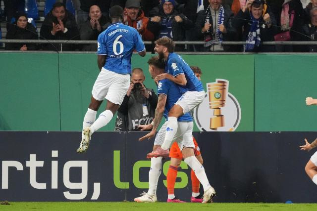 29 October 2025, Hesse, Darmstadt: Darmstadt's Matej Maglica (C) celebrates scoring his side's second goal with teammates Patric Pfeiffer (L) and Killian Corredor during the German DFB Cup 2nd round soccer match between Darmstadt 98 and FC Schalke 04 at Merck-Stadion am Boellenfalltor. Photo: Marc Schüler/dpa - WICHTIGER HINWEIS: Gemäß den Vorgaben der DFL Deutsche Fußball Liga bzw. des DFB Deutscher Fußball-Bund ist es untersagt, in dem Stadion und/oder vom Spiel angefertigte Fotoaufnahmen in Form von Sequenzbildern und/oder videoähnlichen Fotostrecken zu verwerten bzw. verwerten zu lassen.