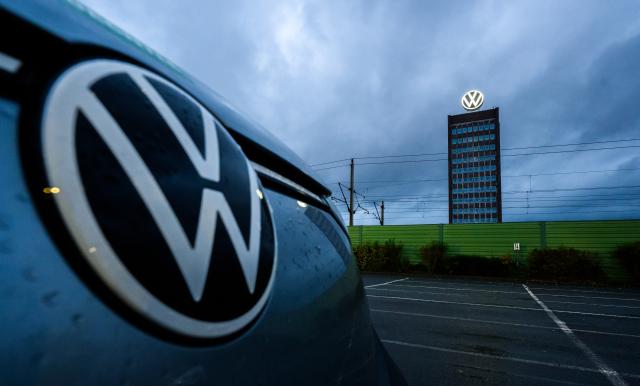 30 October 2025, Lower Saxony, Wolfsburg: A Volkswagen parked in front of the Volkswagen brand tower at the site of the VW main plant. Photo: Julian Stratenschulte/dpa